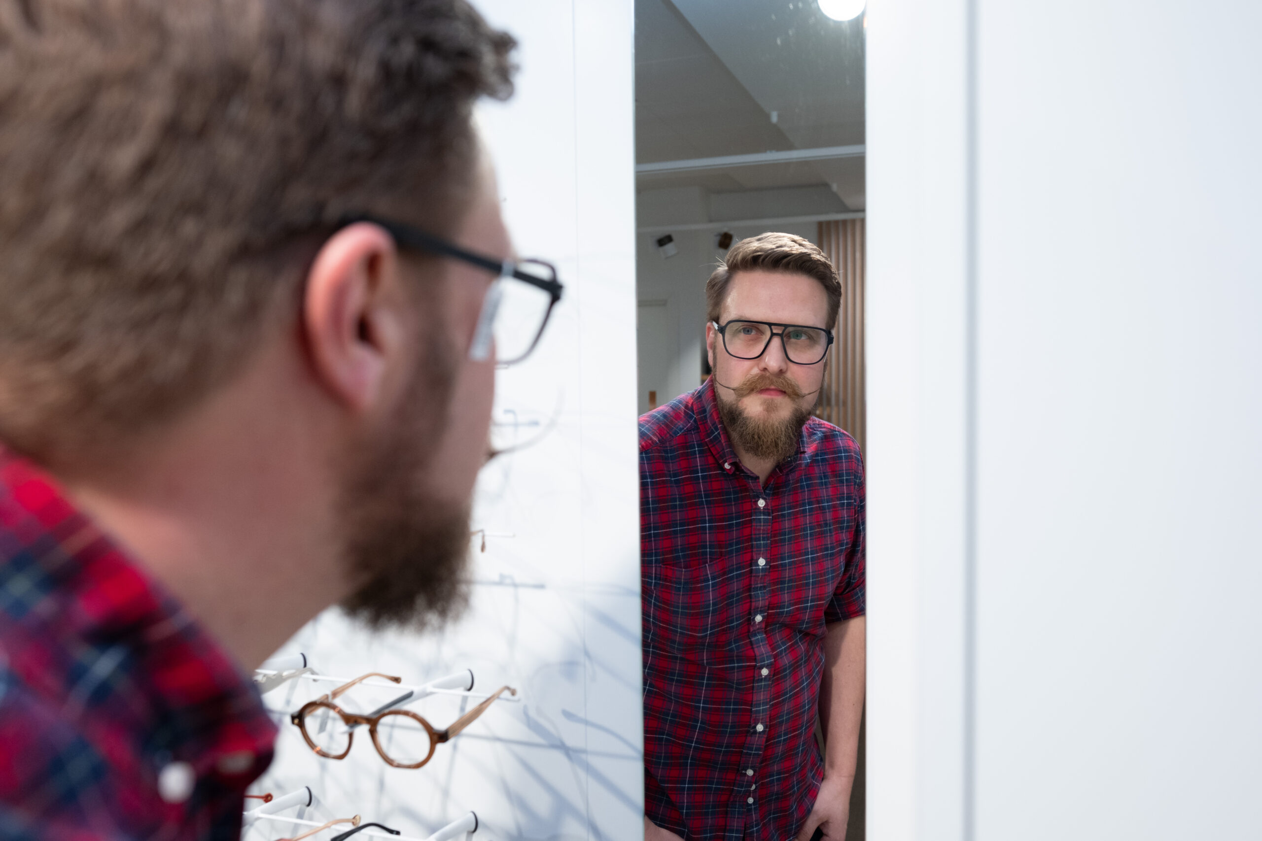 Kunde ser seg i speil med briller